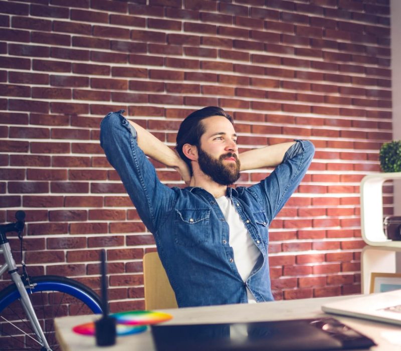 thoughtful-businessman-with-hands-behind-back-relaxing-in-creative-office-1.jpg